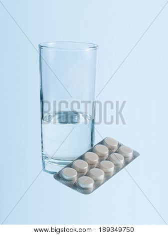 Glass of water and blister pack of pills