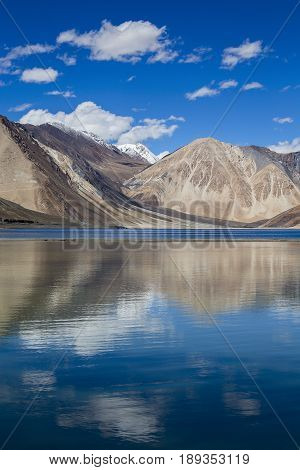 Sunny day at Pangong Lake water and Himalayan mountain in India. Pangong Lake is an endorheic lake in the Himalayas situated at a height of about 4350 m in Ladakh India. It is 134 km long from India to Tibet