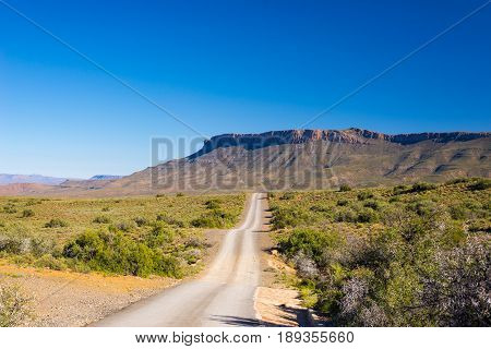 Gravel Road Crossing The Majestic Landscape At Karoo National Park, Travel Destination In South Afri