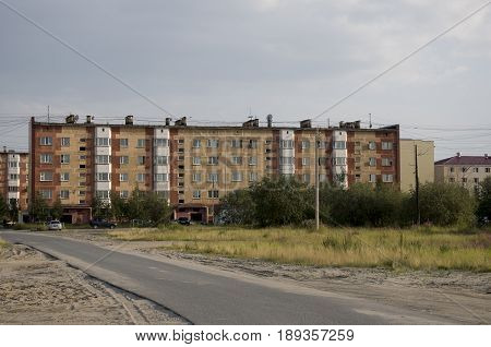 Modern five-storeyed house with flats. It was colored in red, orange and white colors