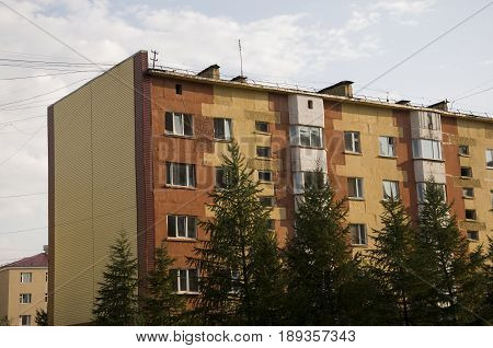 Modern five-storeyed house with flats. It was colored in red, orange and white colors