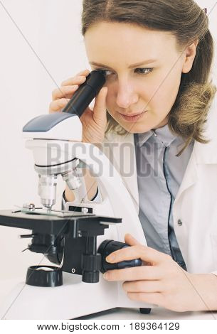 Female scientist using microscope in a aboratory.