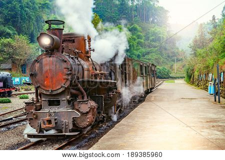 Steam narrow-gauge train with local people stands at the station on the way from Bagou to Yuejin. Mifenguan. Jiayang Mining Region. Sichuan province. China.