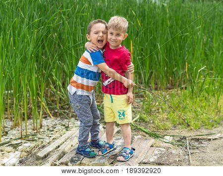 Two little boys friends hug each other in summer sunny day. Brother love. Concept friendship. Portrait of two boys brothers and best friends smiling. Friends hugging.