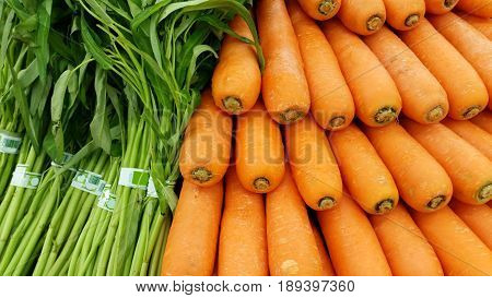 Heap of farm grown fresh carrot and vegetable Ready for sell of Chinese morning glory in the market
