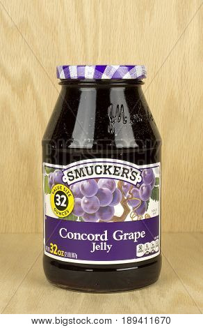 RIVER FALLS,WISCONSIN-JUNE 03,2017: A jar of Smucker's brand concord grape jelly with a wood background.