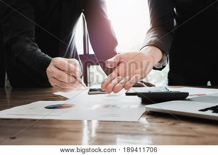 Young Business Man Pointing Graph Chart With Pathner For Analyze Plans In This Mounth. Vintage Tone.