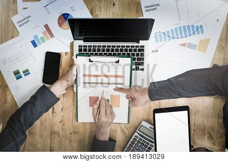 Businessman pointing graph chart with pathner for analyze plans in this mounth. vintage tone.