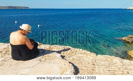 mum and beaby on rocky beach enjoy view and breastfeeding in public