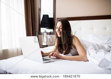 Pretty Woman Using Her Laptop In Bed At Home