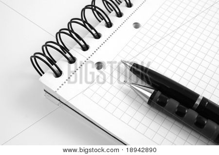 černé kuličkové pero a tužka na notebook