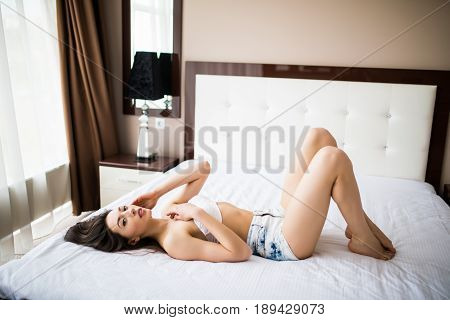 Happy Girl Lies On A Bed. Happy Young Woman Lying On The Bed With Legs