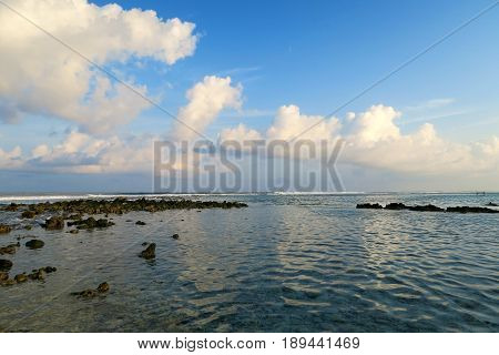 Local surfing spot on Himmafushi island, Maldives: clouds reflection in ocean with evening light