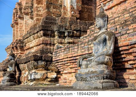 Ancient Buddha statue sitting posture around the chapel among the ruins of Wat Maha That temple at Sukhothai Historical Park is an old city and famous attractions Sukhothai Province Thailand