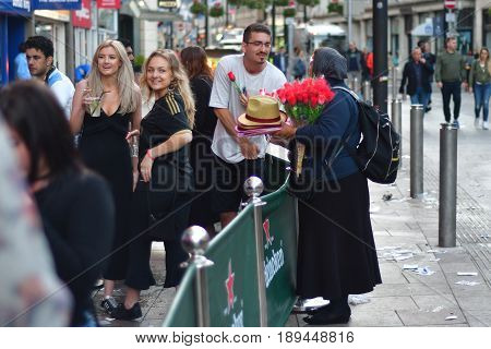 CARDIFF UK - 3 JUNE 2017 Flower seller and partygoers during Champions League Final. British police and security services on high alert as hundreds of thousands of fans enjoy football in the capital of Wales