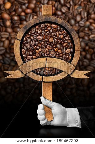 Waiter holding a wooden sign with roasted coffee beans and copy space. On a dark background with many coffee beans