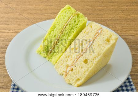 Snack and Dessert Green Pandan and Vanilla Chiffon Cake Made With Butter Eggs Sugar Flour Baking Powder and Flavorings on White Dish.