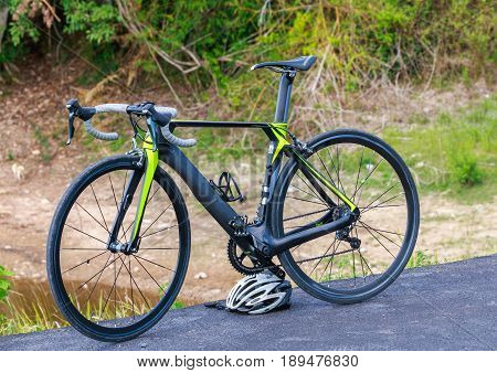 Cyclo cross bicycle with a helmet standing at the road near reservoir