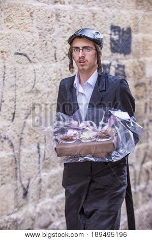 JERUSALEM - MARCH 13 : Ultra Orthodox man holding Mishloach Manot during Purim in Mea Shearim Jerusalem on March 13 2017 Mishloach Manot is traditional food gifts given during Purim