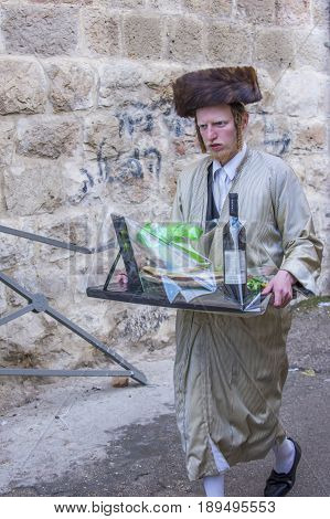 JERUSALEM - MARCH 13 : Ultra Orthodox man holding Mishloach Manot during Purim in Mea Shearim Jerusalem on March 13 2017 Mishloach Manot is traditional food gifts given during Purim