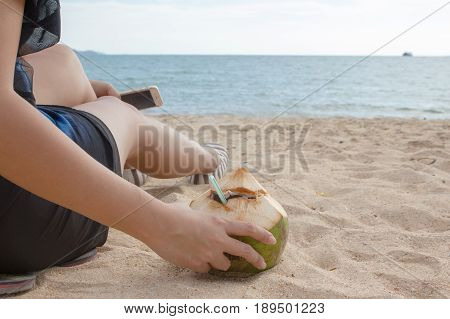 lady sit and will take coconut to drink on the beack