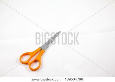 only one orange scissors with white lsolate background