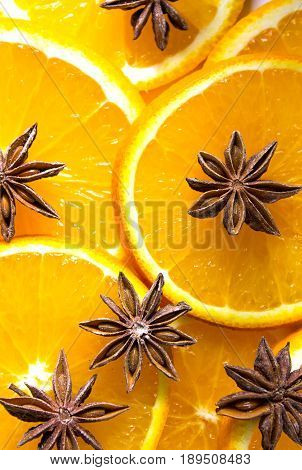 bright orange background from slices of juicy oranges with anise stars cinammon
