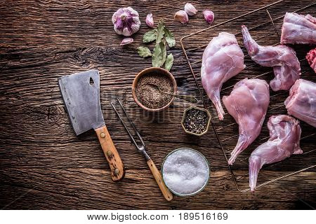 Rabbit. Raw rabbit slices with spices garlic kitchen utensilfork and butcher. Hunting cuisine.