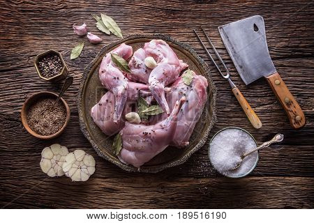Rabbit. Raw rabbit slices with spices garlic kitchen utensilfork and butcher. Hunting cuisine.