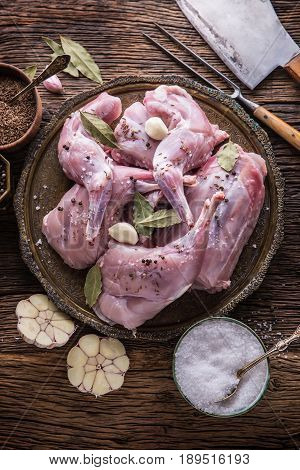 Rabbit. Raw rabbit slices with spices garlic kitchen utensilfork and butcher. Hunting cuisine.