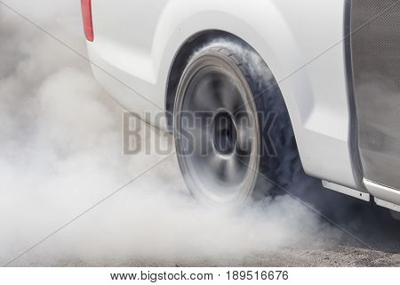 Race car burns rubber off its tires in preparation for the race