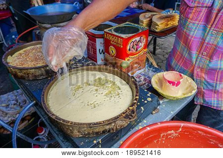 Kota Kinabalu,Sabah-May 28,2017:Street vendor preparing traditional Apam Balik or Terang Bulan cuisine at street bazaar in Kota Kinabalu,Sabah,Malaysia.It's a type of griddle pancake common in Brunei,Indonesia,Singapore & Malaysia.