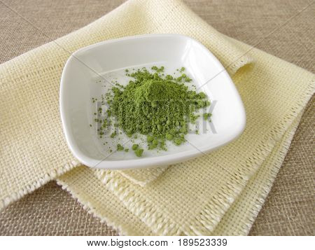 Ground matcha tea powder in small bowl