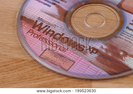SARANSK, RUSSIA - MAY 24, 2017: Windows XP CD disk on wooden background.