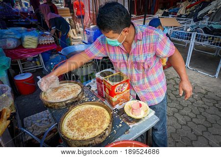 Kota Kinabalu,Sabah-May 28,2017:Street vendor preparing traditional Apam Balik or Terang Bulan cuisine at street bazaar in Kota Kinabalu,Sabah,Malaysia.It's a type of griddle pancake common in Brunei,Indonesia,Singapore & Malaysia.
