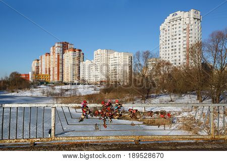 Love locks on the bridge against the background of a new residential district. Balashikha, Moscow region, Russia.