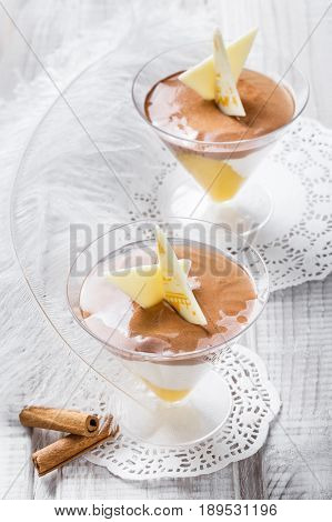Tasty fruit mousse dessert with white chocolate in a glass on light background close up. Delicious dessert and candy bar. Top view.