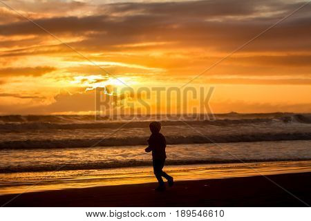 outdoor portrait of young happy smiling child girl in knitted hat on outdoor natural background