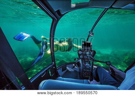Underwater submarine ship following a woman in apnea swimming in tropical turquoise sea of Racha Noi, Phuket in Thailand. cockpit interior view