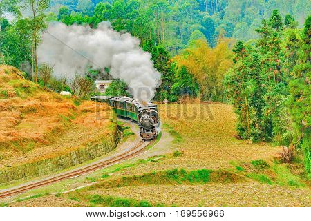 Steam narrow-gauge train moves from Yuejin to Bagou through the chinese countryside. Jiayang Mining Region. Sichuan province. China
