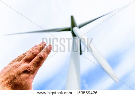 Human hand aiming to wind power turbines generate electricity .