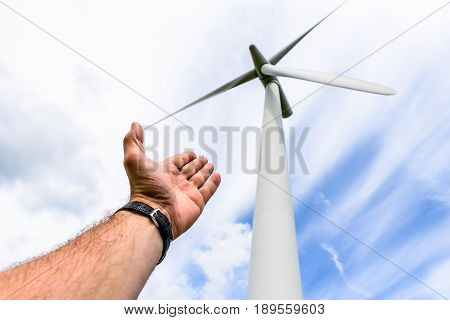 Human hand aiming to wind power turbines generate electricity .