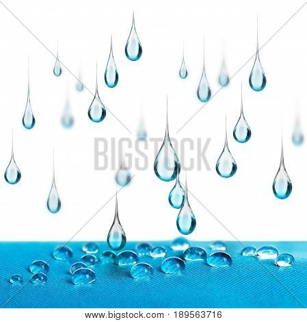 Rain drops fall on blue waterproof fabric