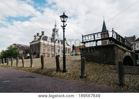Monnickendam Netherlands - August 08 2016. Street view with old traditional houses and bridge over canal in the dutch village of Monnickendam. The town was founded by monks and it is a small fishing village today