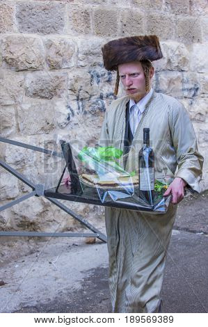 JERUSALEM - MARCH 13 : Ultra Orthodox man holding Mishloach Manot during Purim in Mea Shearim Jerusalem on March 13 2017 Mishloach Manot is traditional food gifts given during Purim