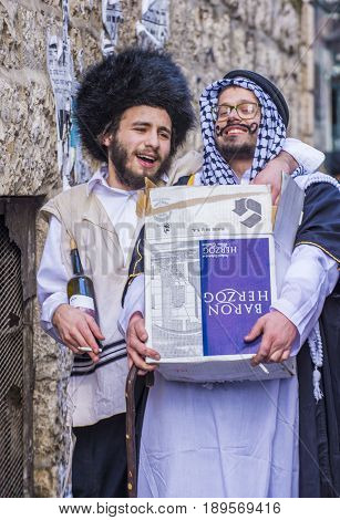 JERUSALEM - MARCH 13 : Ultra Orthodox men holding Mishloach Manot during Purim in Mea Shearim Jerusalem on March 13 2017 Mishloach Manot is traditional food gifts given during Purim