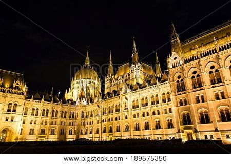 Budapest parliament building at night with dark sky.