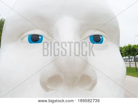 LELYSTAD NETHERLANDS - AUGUST 7 2016: closeup of a statue of a white head with blue eyes made by Henk Hofstra