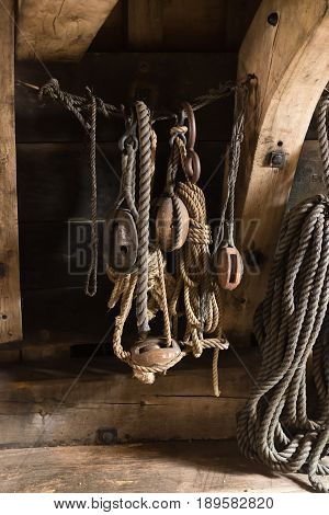 ancient wooden sailboat pulleys and ropes in an old restored dutch VOC ship