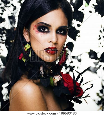 pretty brunette woman with rose jewelry, black and red, bright make up kike a vampire closeup red lips, halloween concept
